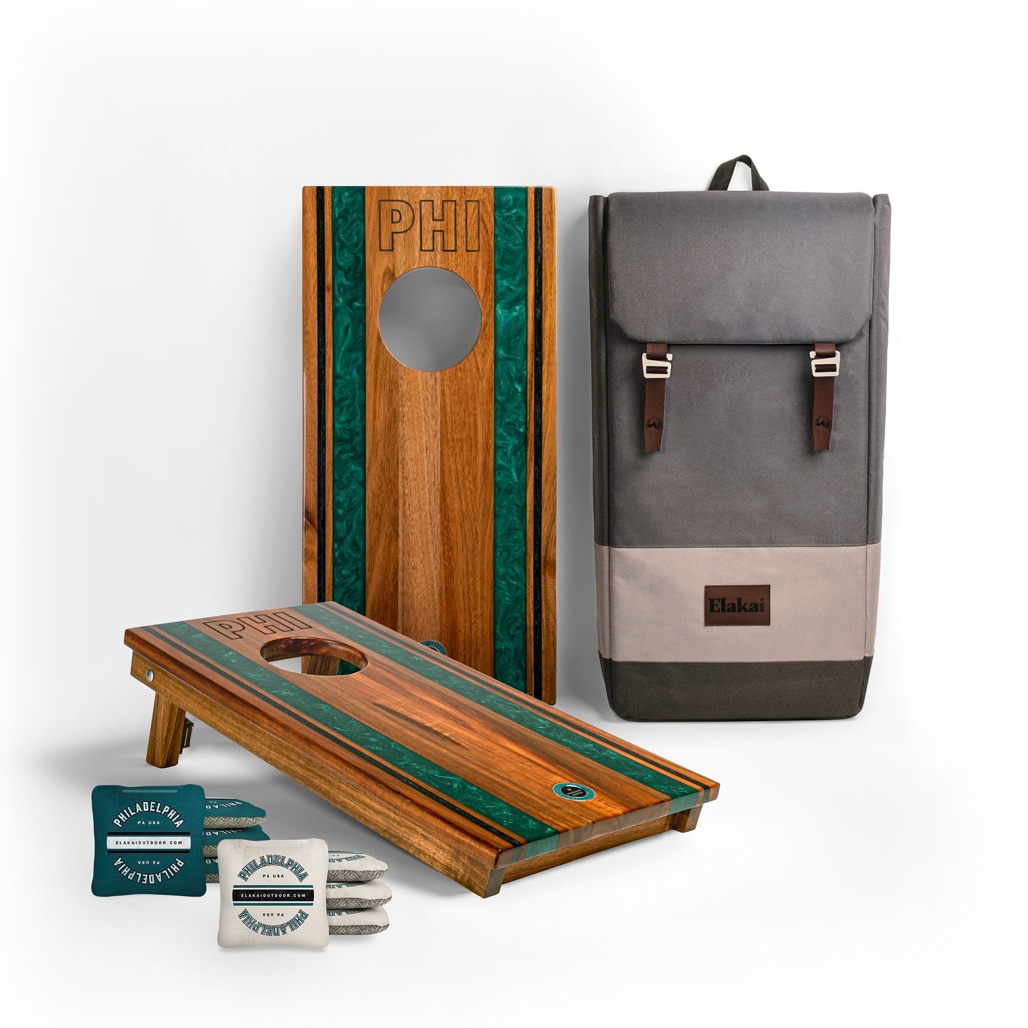 Wooden cornhole boards with green accents, a gray backpack, and small items on a white background.
#color_philadelphia