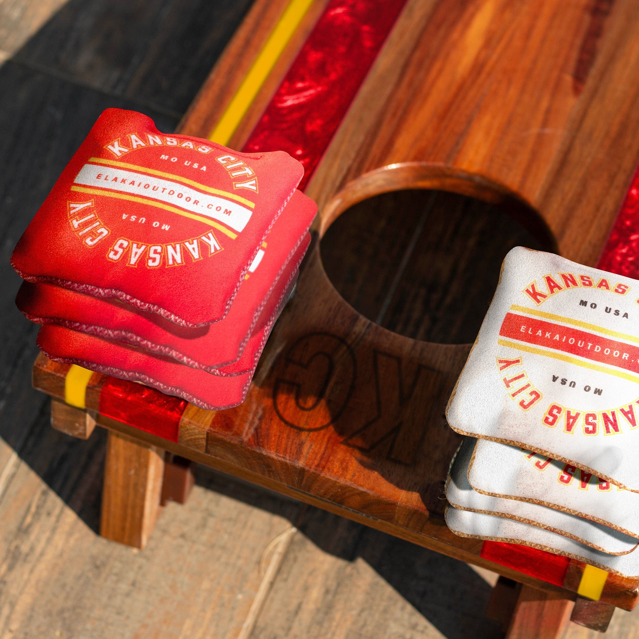 Red and white cornhole bags with 'Kansas City' branding on a cornhole board

#color_kansas city