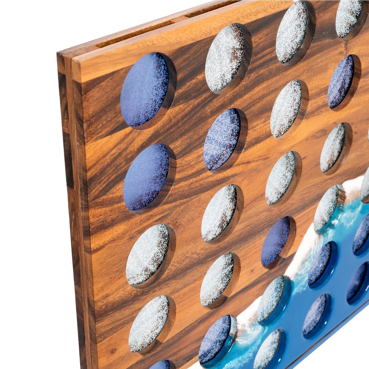Close-up of the Studio Series giant four in a row board, sea-glass chips seated in acacia wood and blue epoxy resin holes